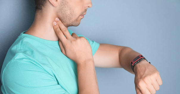 A person in a teal shirt checks their pulse at the neck artery, specifically the common carotid artery. This action highlights the importance of monitoring the carotid artery, which branches into the external carotid artery, for cardiovascular health.