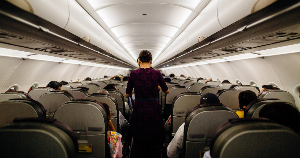 Traveller moving through the aisle of an airplane during a flight.